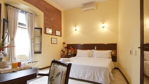 A hotel room with a bed, bedside table, chair, and a window with curtains. - Direita S.Antonio-Comfort Street Quarto e sala para 5 pessoas, vista c.historico. (Salvador)
