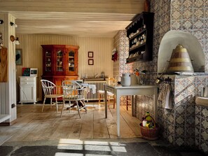 A traditional kitchen with wooden cabinets, a dining table, chairs, and a tiled backsplash. - Pazo de Cedofeita (Ribadeo). Historical house of the XVI century, with private property. (Ribadeo)