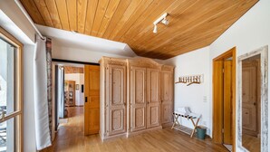 A spacious room with wooden flooring, a high ceiling, and a view of a hallway. - Apartment "Time Out in the Black Forest" with Private Terrace, Garden & Wi-Fi (Schonach im Schwarzwald)