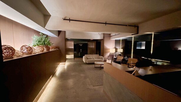 Ein modernes Interieur mit einer Couch, einem Fernseher und einer Rezeption.