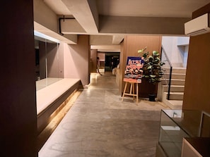 A hallway with a reception desk, a staircase, and a poster. - Isaiah 4110 Condo Stay (Cebu City)
