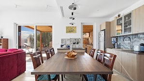 Una cocina moderna con una mesa de comedor de madera, sillas y un sofá rojo.