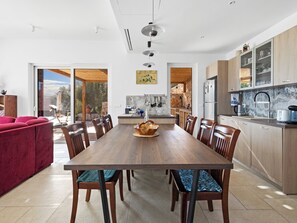 Eine moderne Küche mit einem Holzespeisetisch, Stühlen und einem roten Sofa.