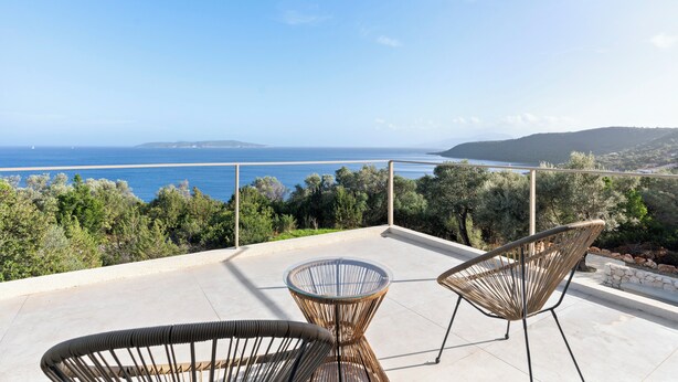 A terrace with two wicker chairs and a glass table, overlooking a beach and the sea. - Villa Thymari, new cocoon of privacy and peace (sivota village)