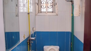 Ein Badezimmer mit Toilette, Waschbecken und Fenster.