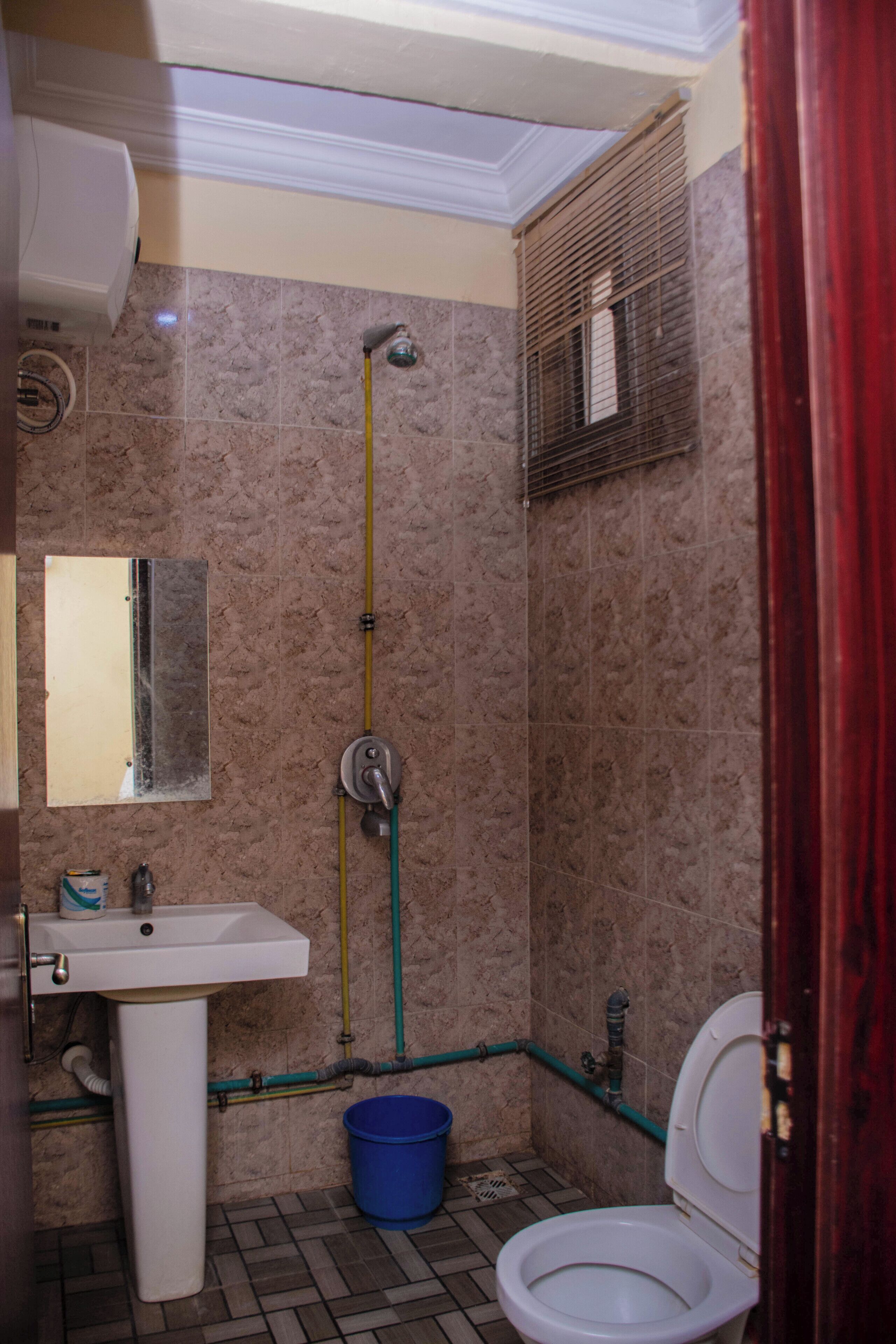 Une salle de bain équipée d’un lavabo, de toilettes, d’une douche et d’un miroir.