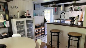 Een keuken met een eethoek, inclusief een tafel, stoelen en een barkruk.
