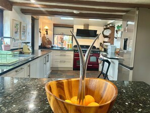 Una cocina con un cuenco de madera sobre la encimera, una estufa y un refrigerador.