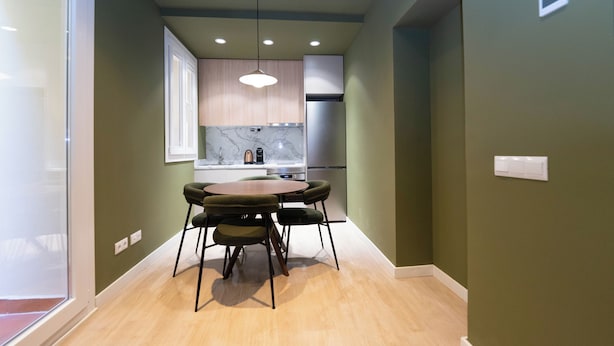 A modern kitchen with a dining area, wooden cabinets, and a marble backsplash. - Be Mate Chamberí - Temporary Stays (Madrid)