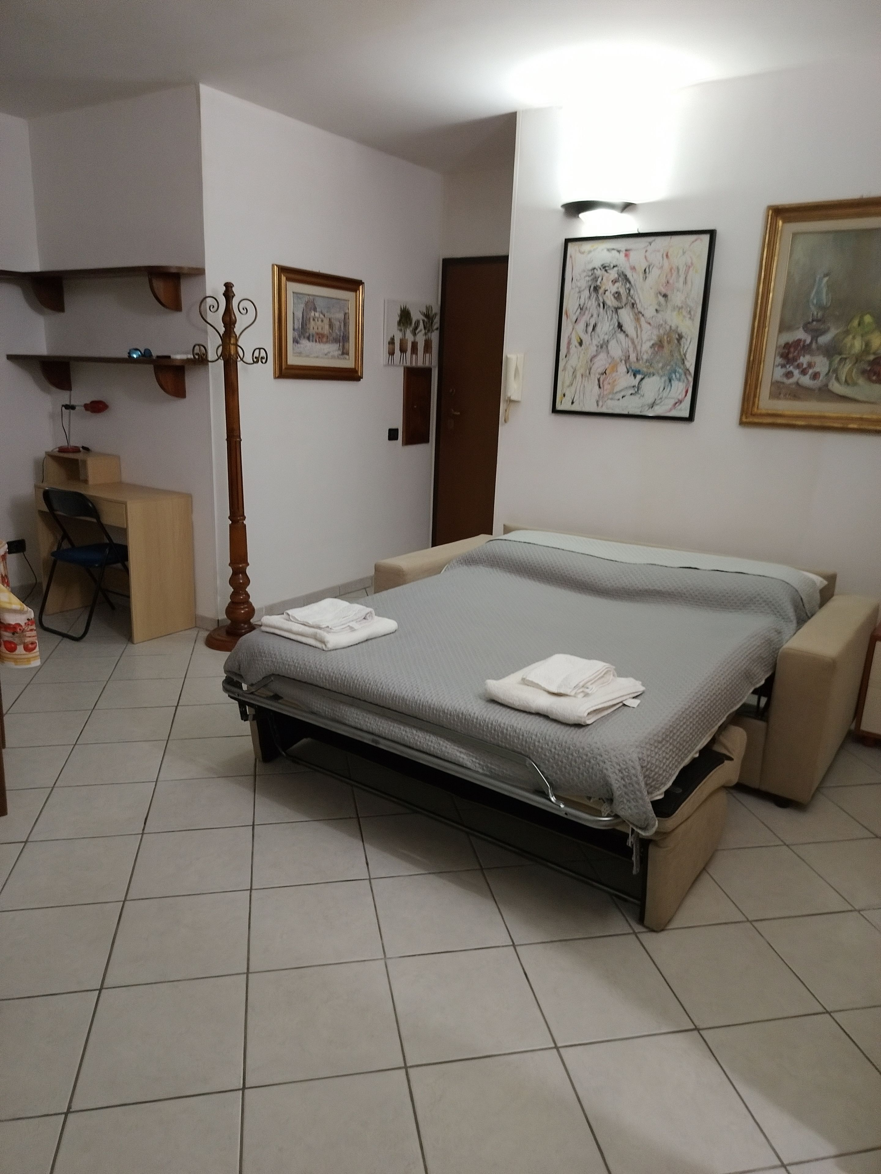 A bedroom with a bed, a desk, and a chair.