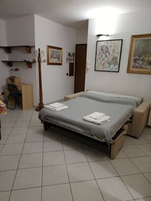 A bedroom with a bed, a desk, and a chair. - De Blasi Studio Apartment (Lecce)