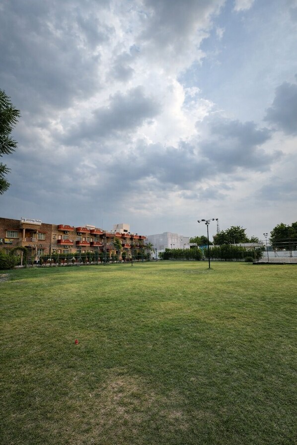 A grassy field with a building in the background. - Udaigarh Palace - The Heritage Hotel  (Jodhpur)