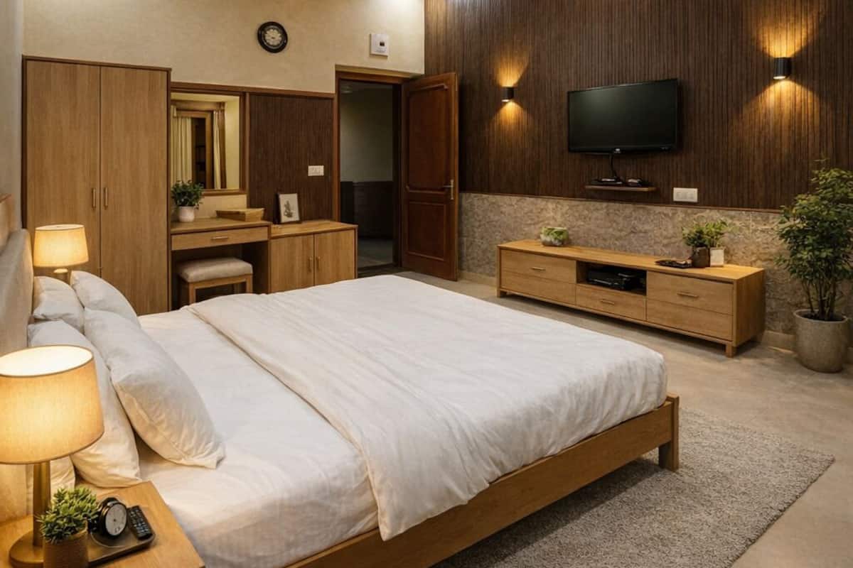 A modern bedroom with a bed, bedside tables, a TV, and a ceiling fan.