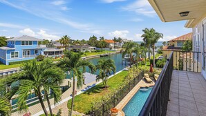 Un quartier résidentiel avec une piscine, des palmiers et des maisons.