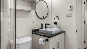 A modern bathroom with a toilet, sink, and cabinets.