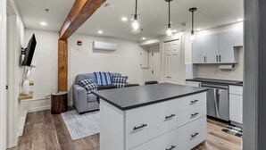 A modern kitchen with a central island, built-in appliances, and pendant lighting.