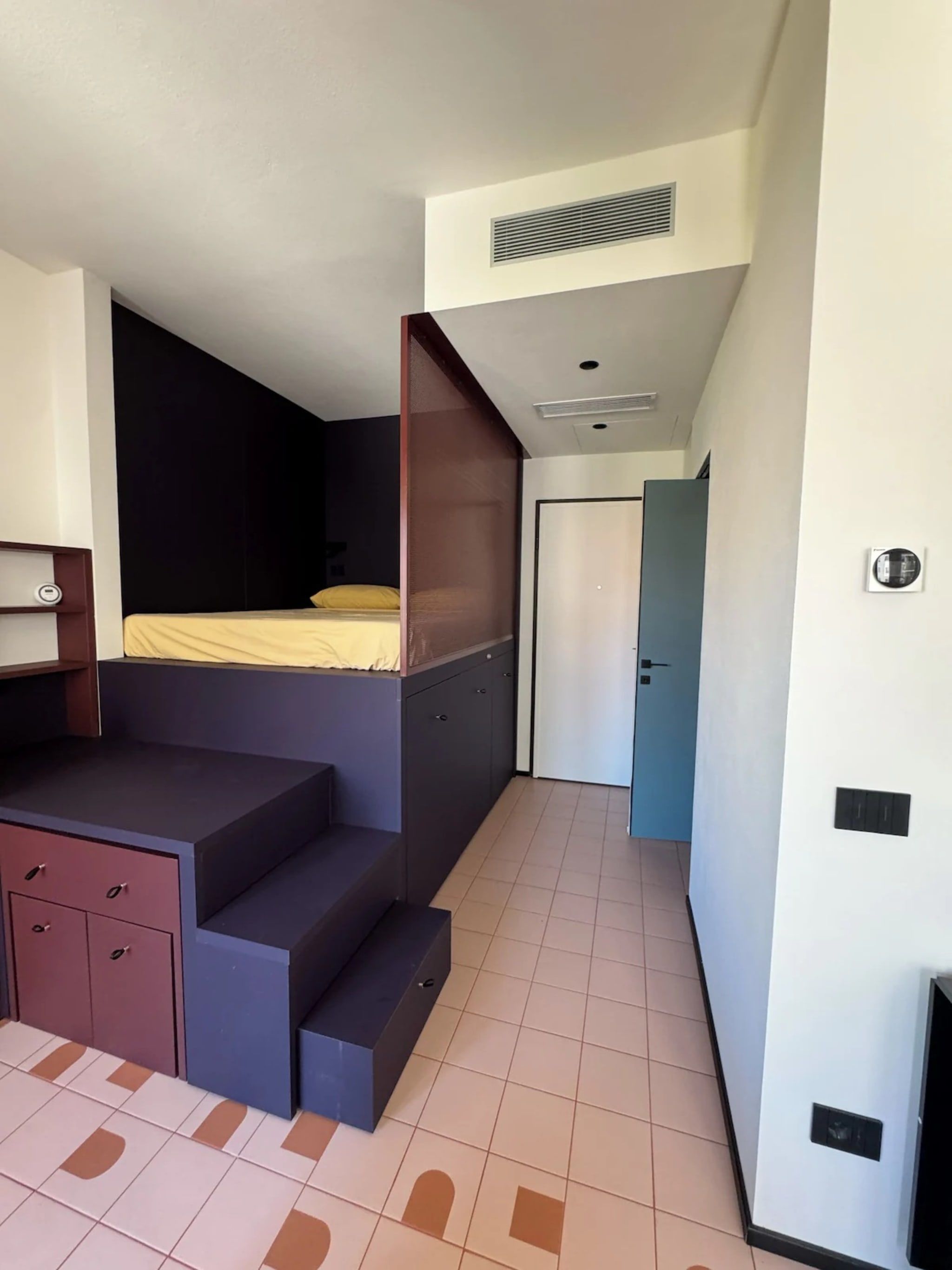Una habitación pequeña con cama, escritorio y armario.