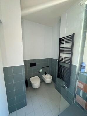 Ein Badezimmer mit Toilette, Bidet und Handtuchhalter.