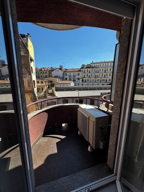 A balcony with a view of a cityscape, a metal railing, and a window frame. - Studio Apartment with Balcony and Parking, 204 (Milano)