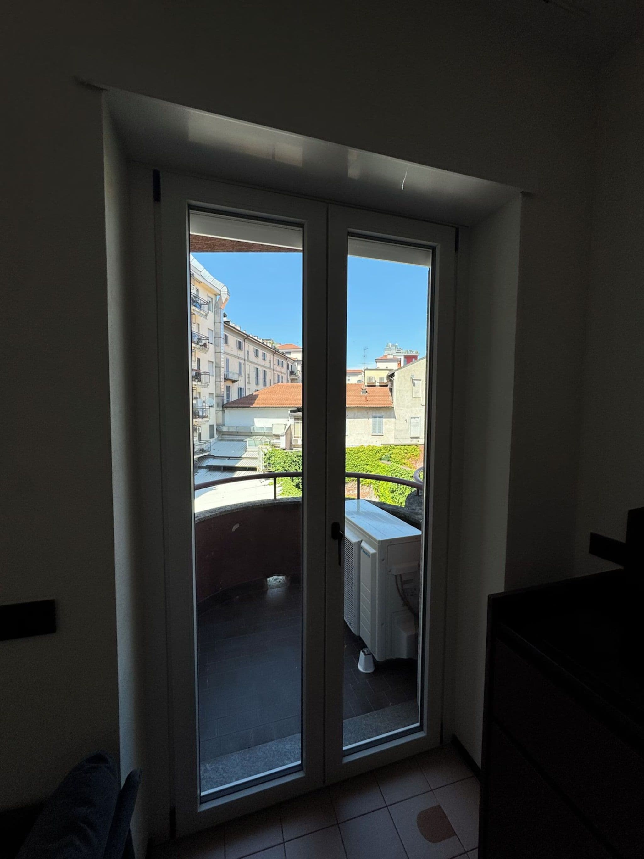 A room with a sliding glass door leading to an outdoor balcony.