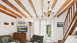 Een woonkamer met een open haard, een televisie en een trap.