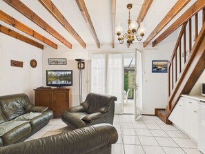 Ein Wohnzimmer mit Kamin, Fernseher und Treppe.