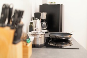 Cuina amb fogó, olles, cafetera i suport per ganivets.