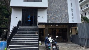 A modern building with a large entrance, a stone facade, and a sign reading 'Fairy Heights.' - Fairy heights  (Kodaikanal)