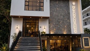 A modern building with a large staircase leading to the entrance, a stone facade, and a sign reading 'FAIRY HEIGHTS'. - Fairy heights  (Kodaikanal)