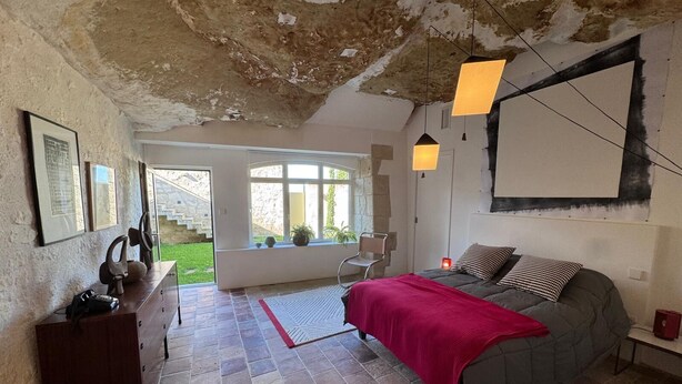 A bedroom with a bed, a desk, a chair, a window, and a view of the outside. - Family suite in troglodyte house with access to indoor swimming pool (La Roche-Clermault)