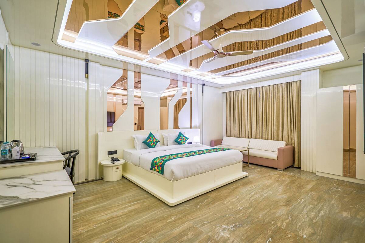 Una habitación de hotel moderna con una cama grande, un escritorio y una zona de estar.