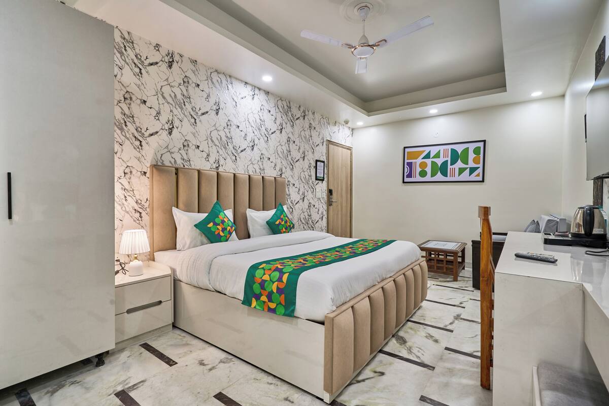 Un dormitorio moderno con cama, mesita de noche, escritorio y ventilador de techo.