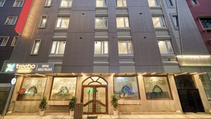 A multi-story hotel with a sign reading 'treebo Royal Gold Palace.'