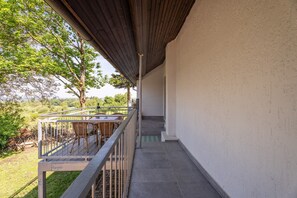 A covered outdoor area with a staircase leading to a balcony, surrounded by greenery and a clear view of the landscape. - Holiday Home “Häusle Felix” with Private Terrace, Shared Garden, and Wi-Fi (Ottersweier)