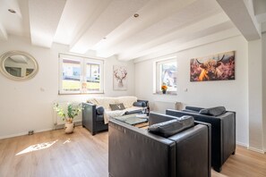 Ein modernes Wohnzimmer mit einer Couch, einem Glastisch und einem Gemälde von einem Stier.