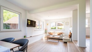 Una sala de estar moderna con un sofá, una mesa de centro y un televisor montado en la pared.