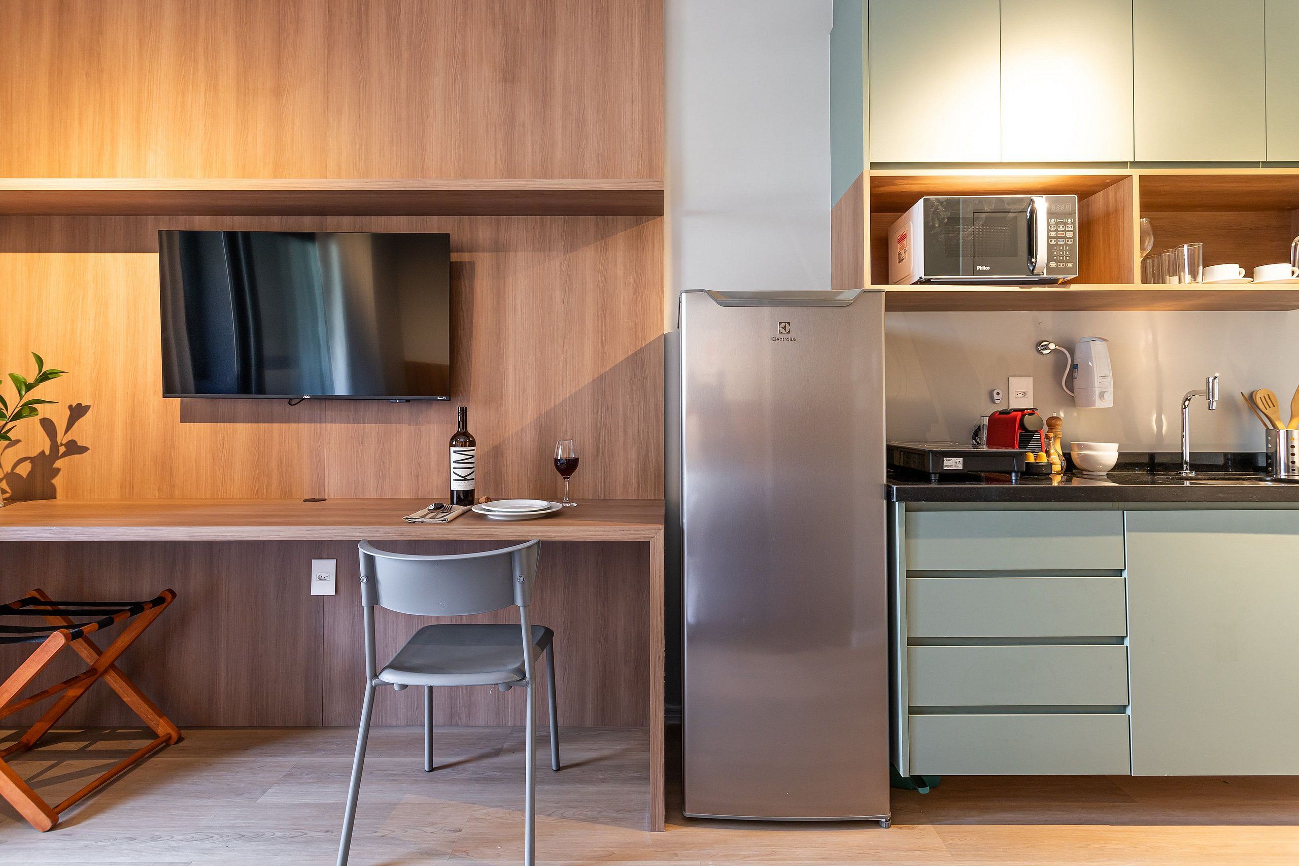 A modern kitchen with a built-in TV, a refrigerator, and a microwave.