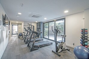 A gym with treadmills, a stationary bike, and exercise balls. - Casa Omaguás by Viva | Apartamentos modernos no coração de Pinheiros (São Paulo)