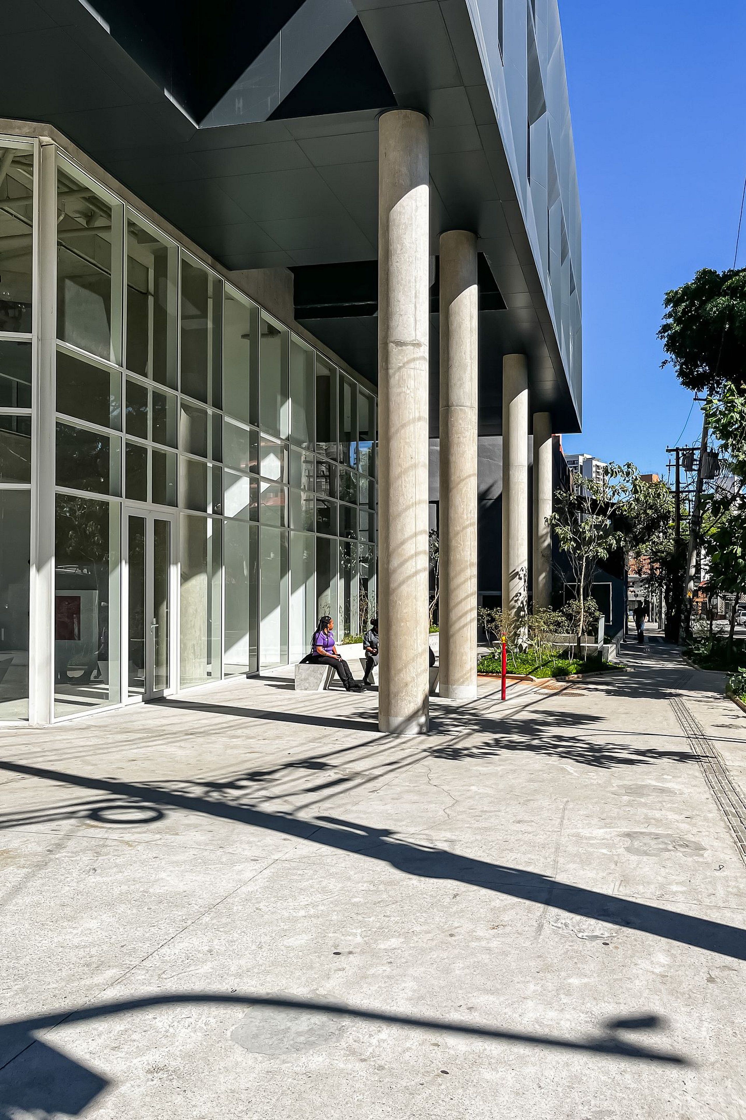 A modern building with large glass windows and concrete columns.