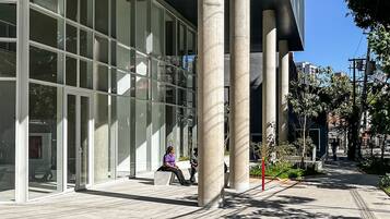 A modern building with large glass windows and concrete columns.