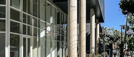 A modern building with large glass windows and concrete columns.