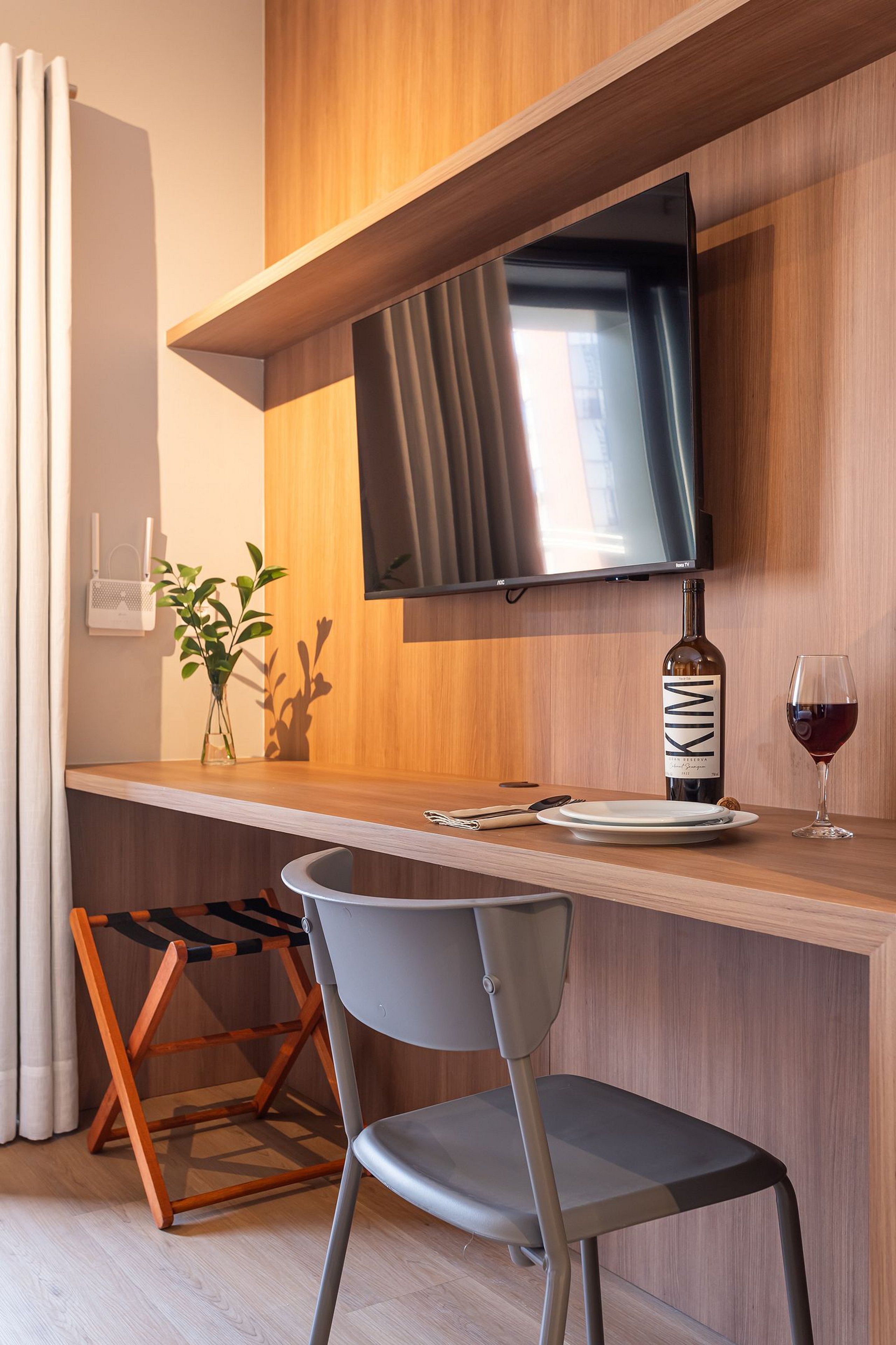 Una cocina moderna con una televisión empotrada, una botella de vino y una copa sobre la encimera.
