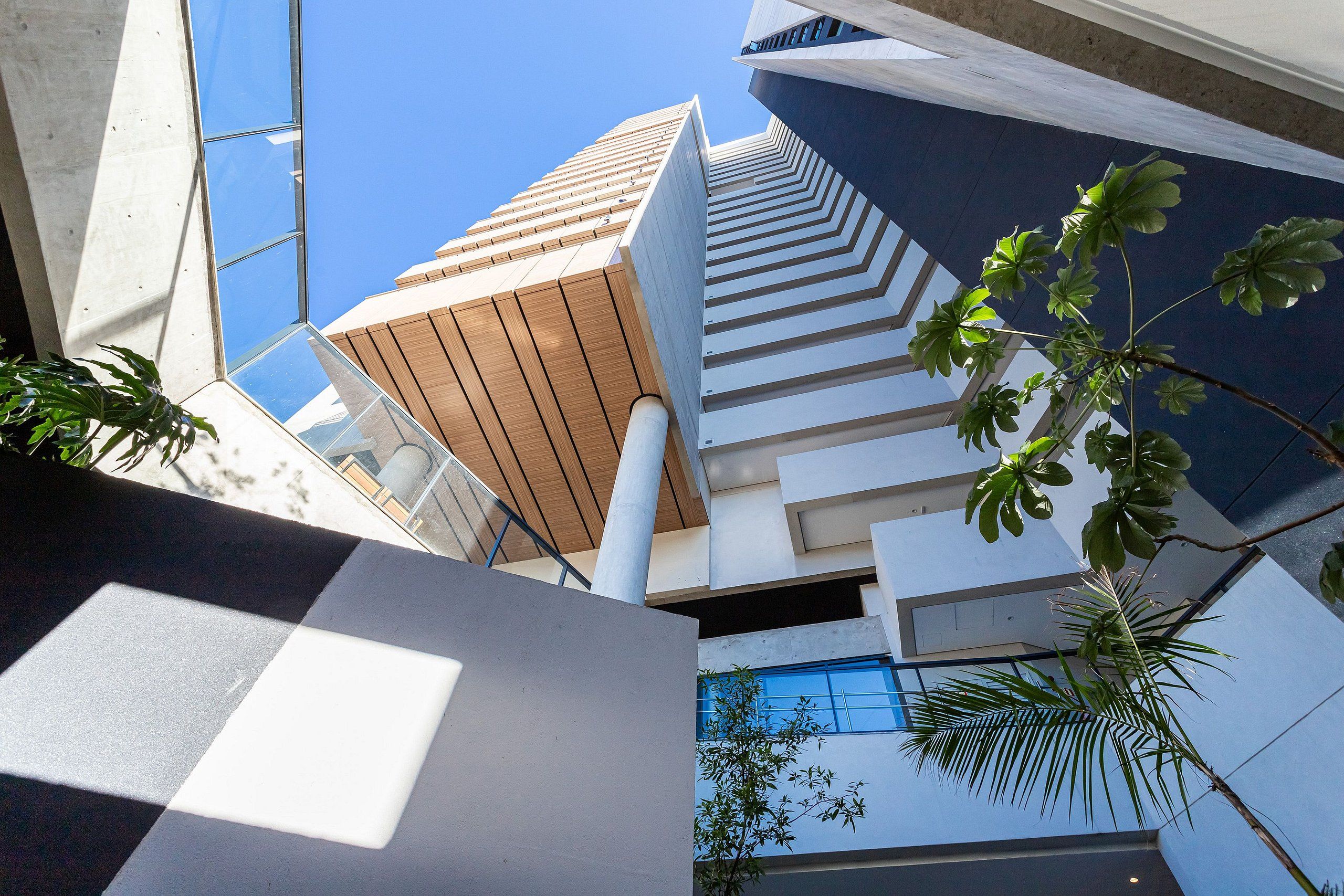A modern building with a unique architectural design, featuring a series of white and wooden panels and a glass facade.