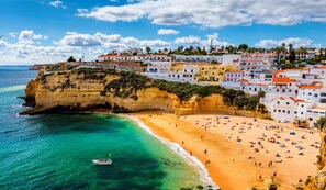 Un pueblo costero con playa, edificios y acantilados.