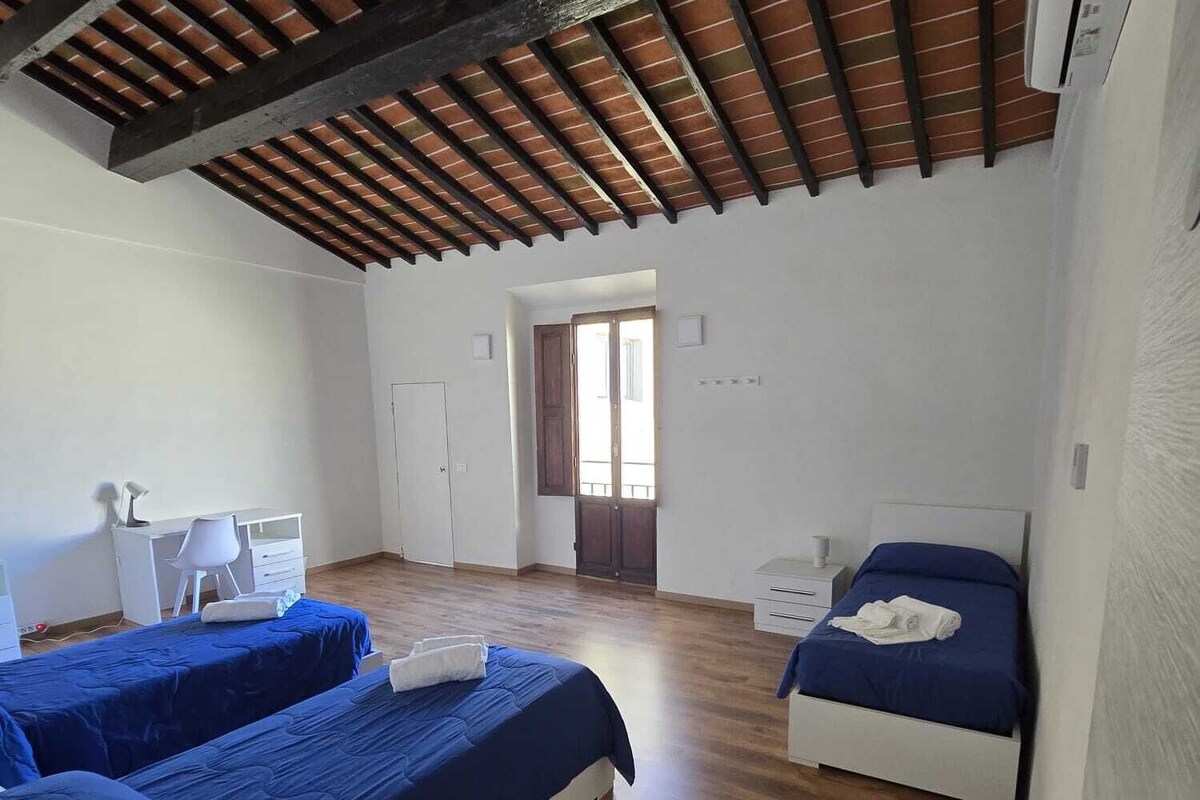 Une chambre avec deux lits, un bureau, une chaise et une armoire.