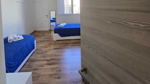 A room with two beds, a wooden door with a number, and a window. - Casa per Ferie degli Angiolini (Florence)