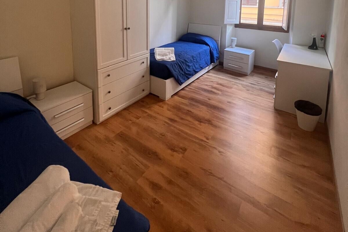 Une chambre à coucher avec un lit, une armoire, un bureau et une fenêtre.