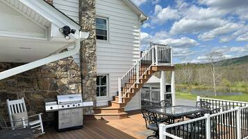 Une terrasse aménagée avec du mobilier d’extérieur, un barbecue et un escalier menant à une autre terrasse.