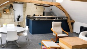 Moderni loft-tyylinen asunto, jossa on keittiö, ruokailutila ja oleskelualue.