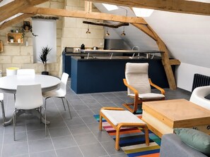Ein modernes Loft mit Küche, Essbereich und Sitzgelegenheiten.